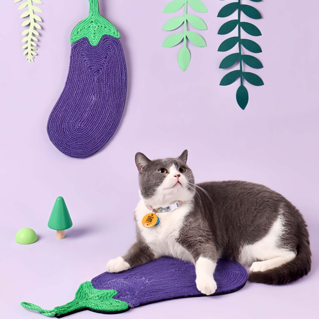 A cat is lying on an eggplant shaped cat sisal scratching pad purple colour petvibez