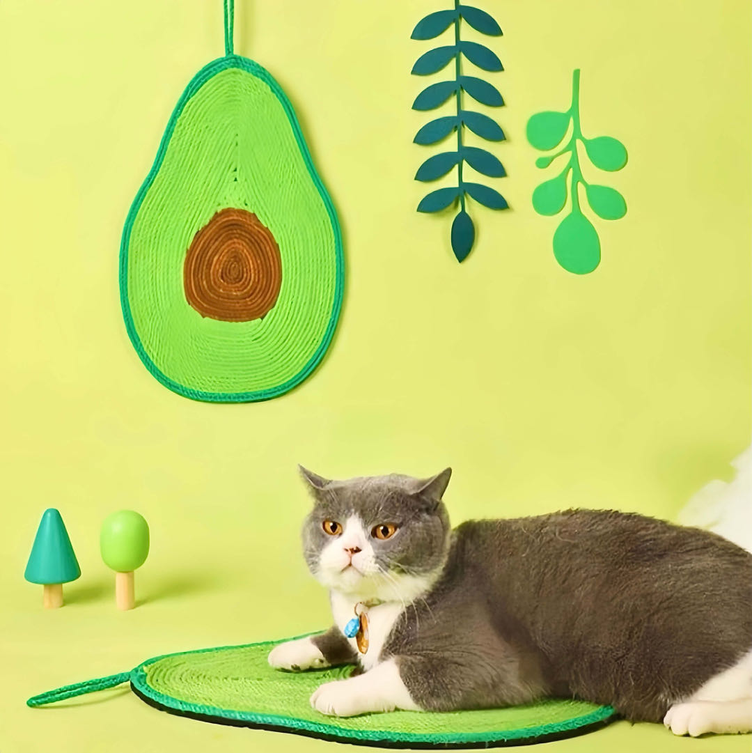 A cat is lying on an avocado shaped cat sisal scratching pad green colour petvibez