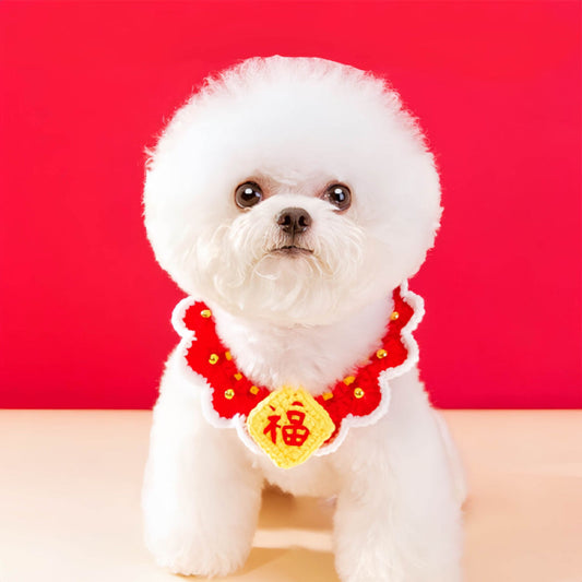 A small white dog wears a red Chinese New Year style adjustable dog collar