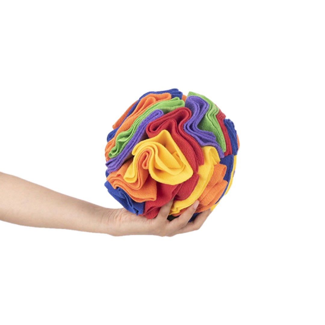 A Hand Is Holding A Rainbow Colour Fleece Dog Snuffle Ball 