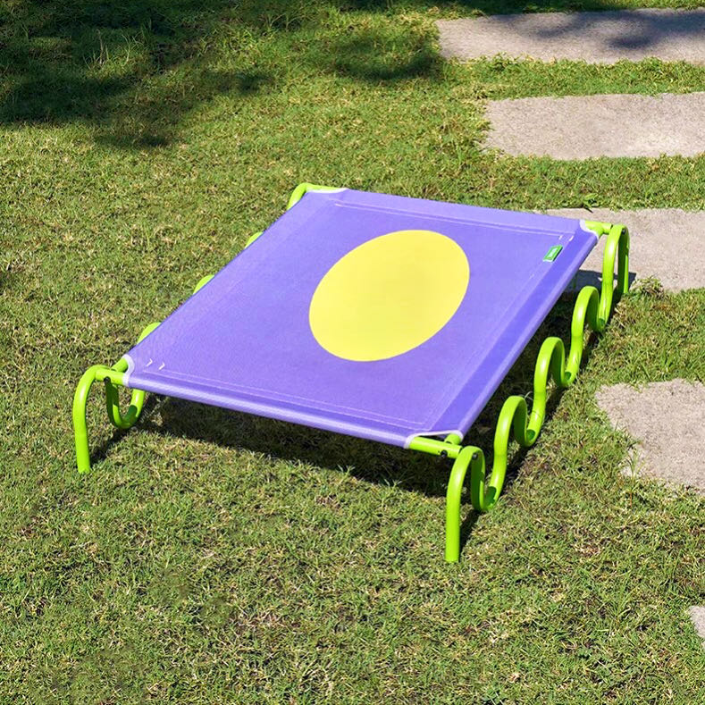 A purple elevated style pet elevated bed on the grass petvibez