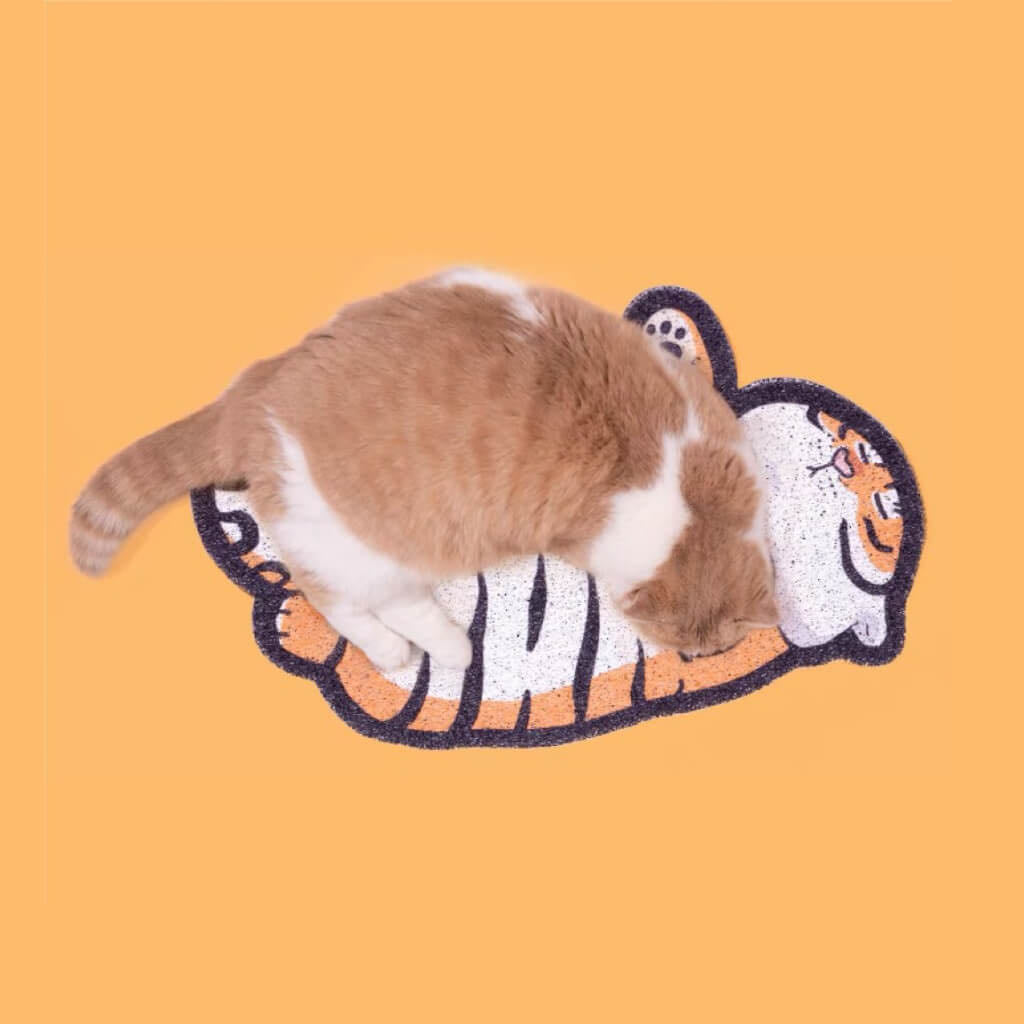 A cat stands on a Tiger Shaped Cat Litter Mat petvibez